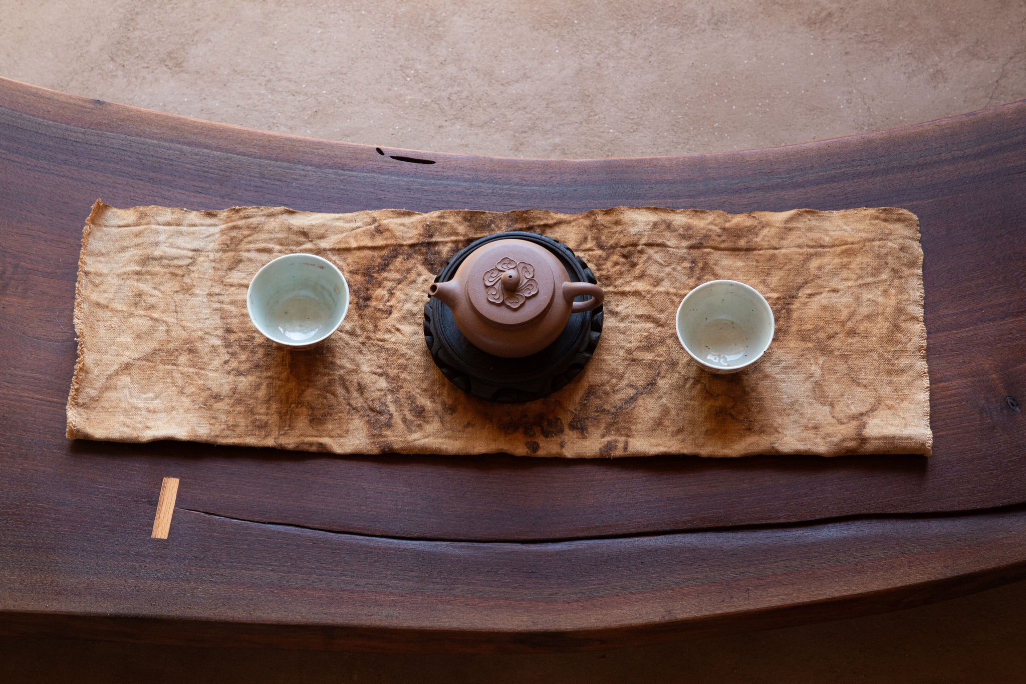 Tea set with a teapot and two cups on a textile.